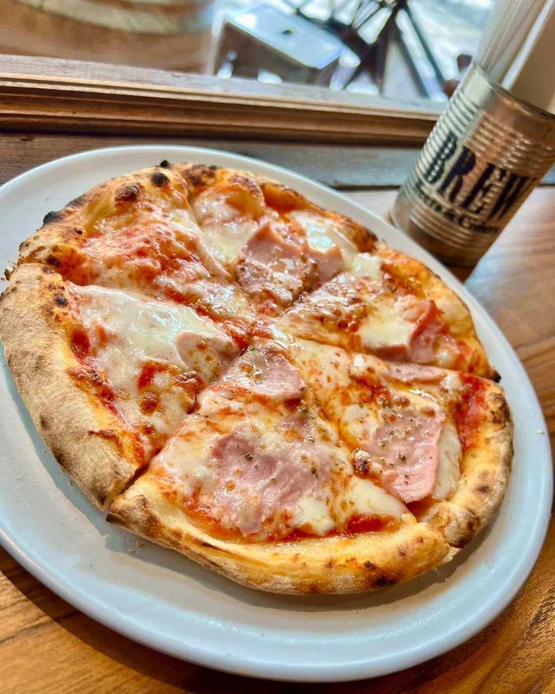 Sourdough pizza on a white plate at Saphan 55